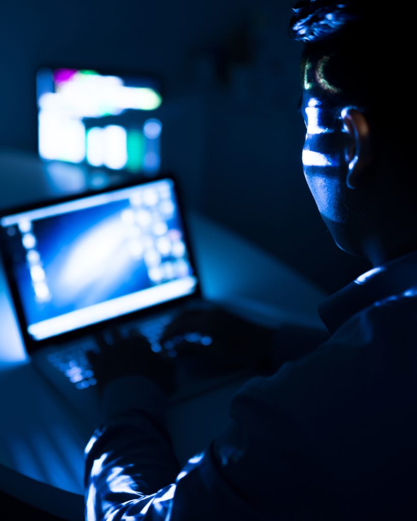 Programmer computing at night, view over the shoulder
